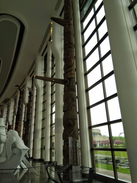 Picture showing a totem reaching across two floors to the ceiling. Totems were much taller than I ever expected, surprisingly also not round but a halved, hollowed trunk